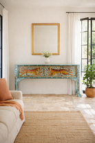 Lifestyle imagination of a hand-painted reclaimed wood console table Bunsee with tiger and leopard motifs in turquoise vintage finish. A unique piece of furniture for bohemian interiors and artistic spaces.