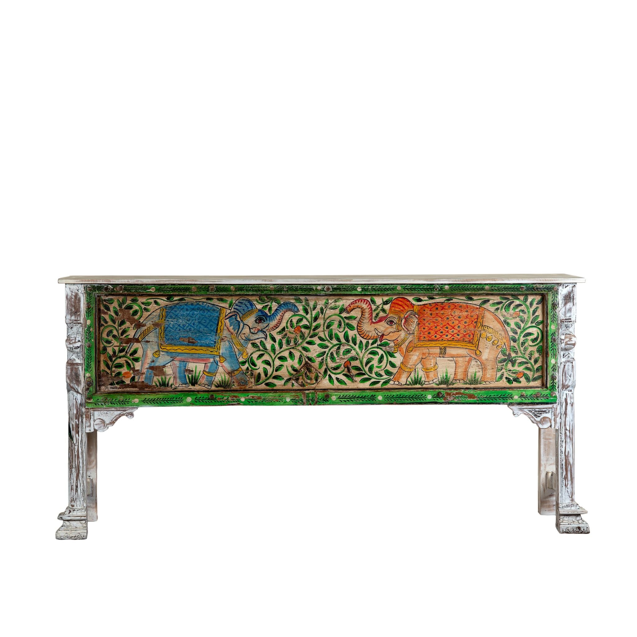 White background image of a hand-painted console table Caara made from reclaimed wood with vibrant elephant motifs and green foliage. A unique furniture piece full of vintage flair for bohemian interiors.