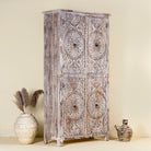 Side view of a hand carved acacia wood cabinet with floral design and 4 doors in a living room scene.