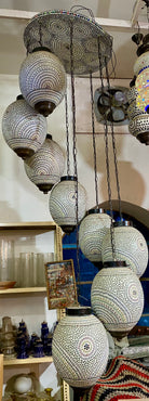 Decorative hanging lamps with intricate designs in a store setting.