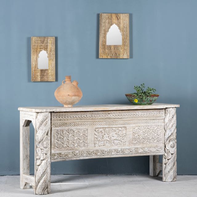 Side angle image of a white-washed carved console table made from reclaimed wood with floral detailing; Mediterranean and Ibiza style furniture, 160 × 80 × 48 cm.