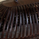 Close up image of a Chitra metal pendant light with hand-forged slatted design and iron chain suspension—an artisanal example of hand crafted metal lamps and bold metal pendant lights for high ceilings.