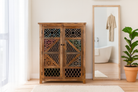 Lifestyle imagination of a handmade mango wood cabinet with carved floral and geometric lattice doors, distressed colour accents; artisanal furniture perfect for boho style interiors, 100 × 45 × 130 cm.