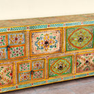 Close up image of a hand painted mango wood chest of 11 drawers with floral motifs; artisanal mango wood furniture and hand painted furniture, 250 × 41 × 85 cm.