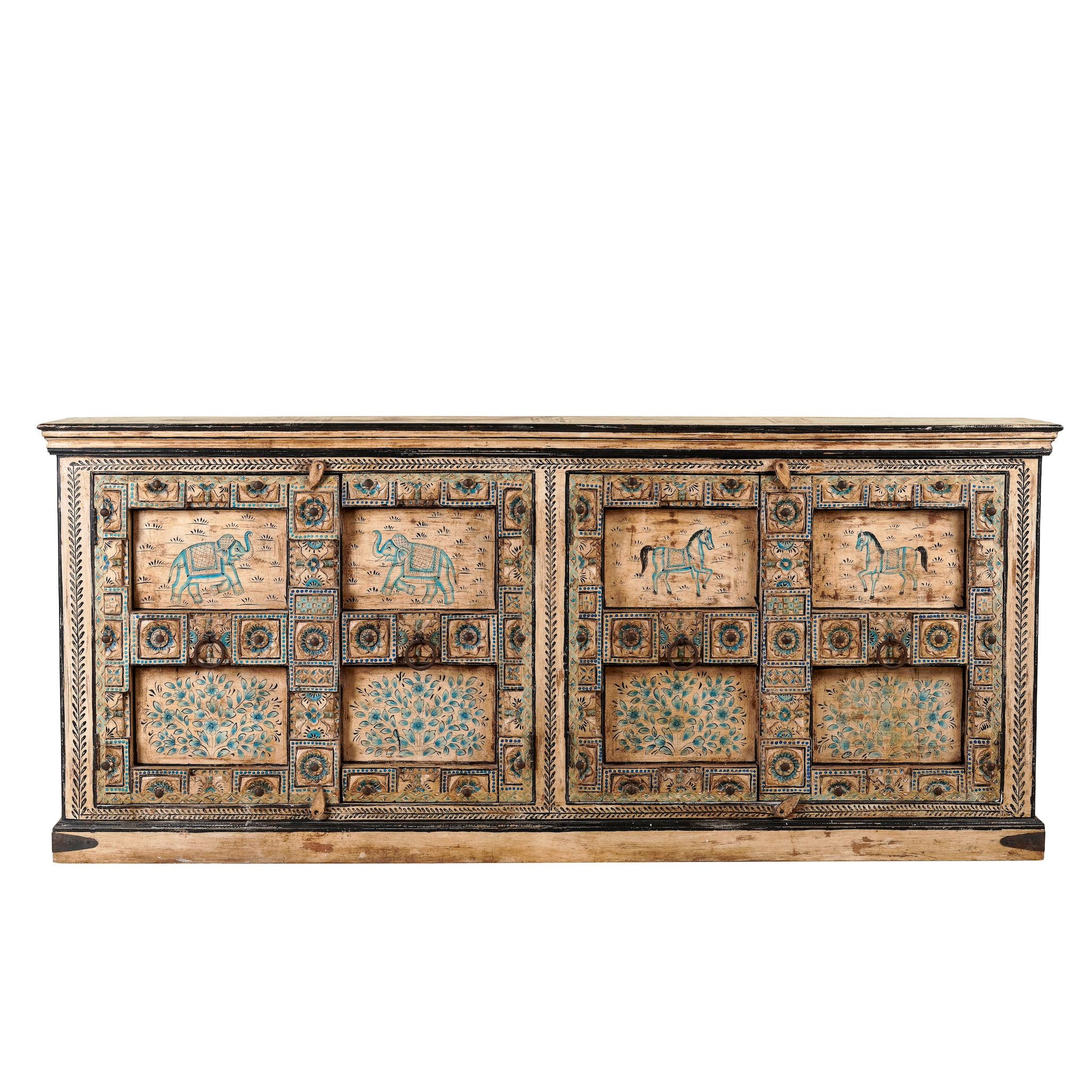White background image of a vintage sideboard made from teak wood, hand-painted with traditional Indian motifs including elephants, camels, horses, and floral patterns in muted teal and earthy tones, featuring detailed borders and a distressed finish. 