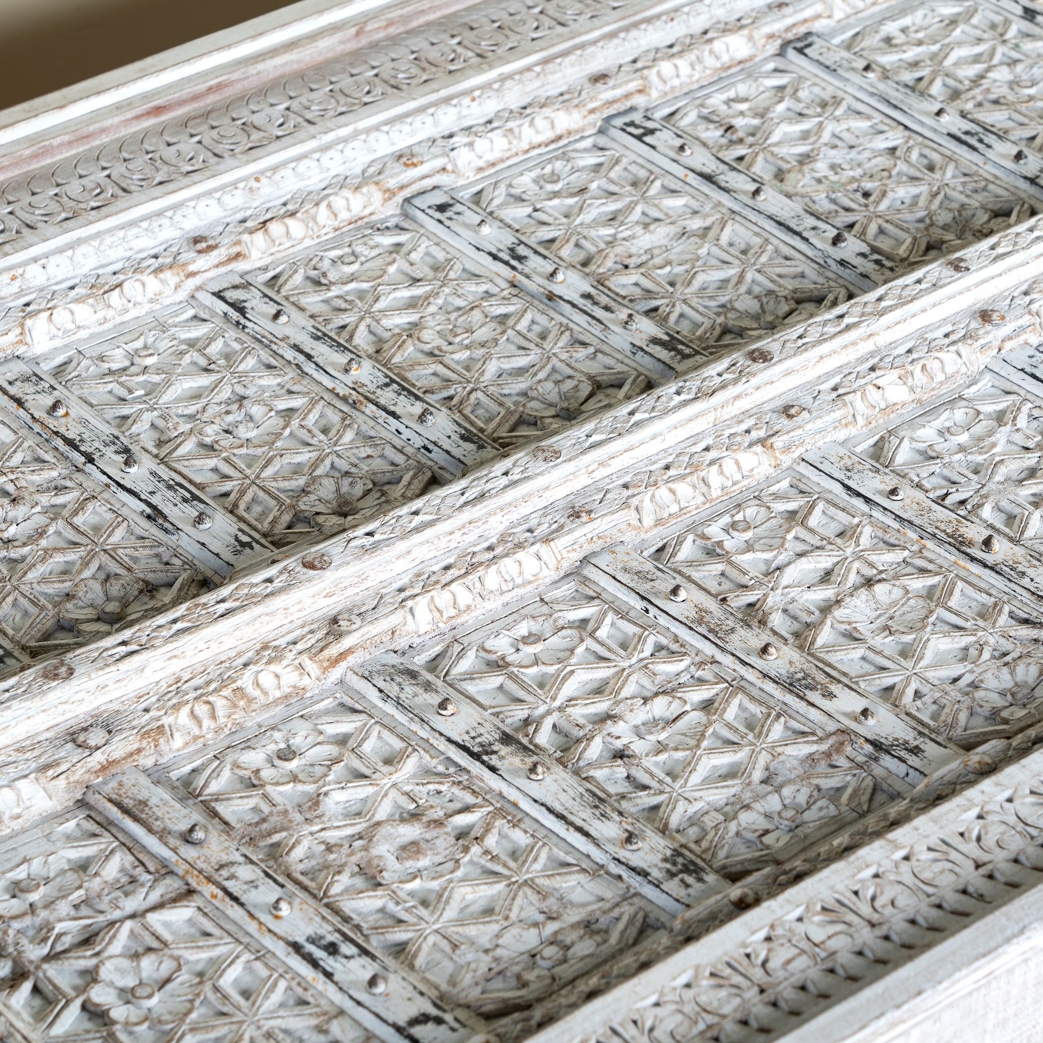 Close up image of a Dhyana white washed old door coffee table made of antique teak wood; handcrafted Indian coffee table, 185 × 109 × 46 cm.