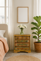 Lifestyle imagination of hand-painted reclaimed wood chest of drawers with floral designs and distressed antique finish; perfect for bohemian interiors and vintage hand painted furniture lovers.