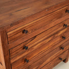 Close up picture of a chest of drawers made from reclaimed teak wood, featuring a minimalist design with five spacious drawers and a warm natural finish- ideal for rustic and modern interiors.