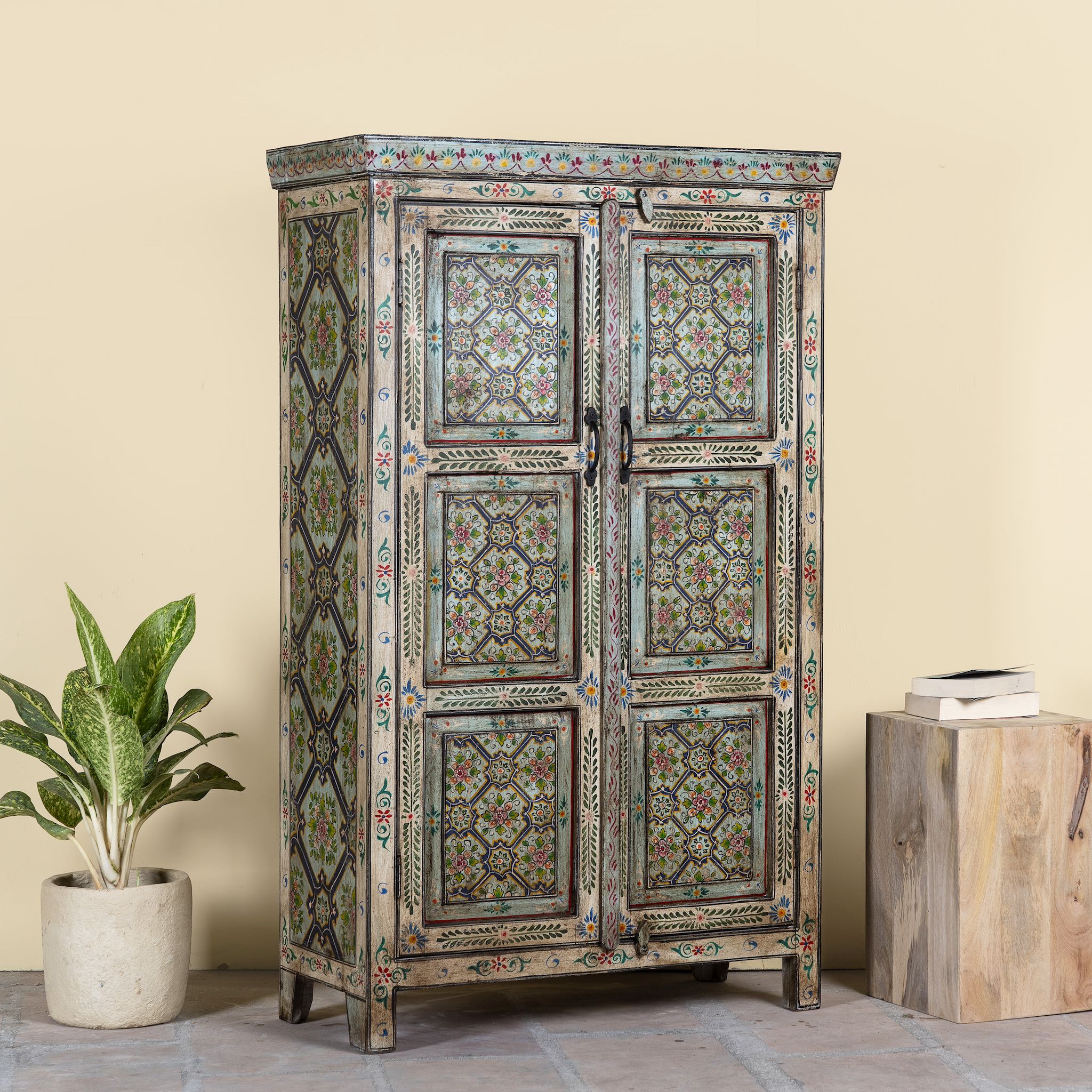Side angle image of a reclaimed wood cabinet with floral and geometric designs, perfect for a bohemian interior with Mediterranean style.