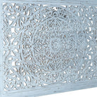 Close up image of a hand-carved wooden bed made of mango wood with large floral panel in white finish – Flair model by Om Home & Garden