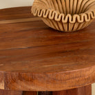 Close up image of a rustic wood coffee table with round reclaimed teak top and black charred finish; sustainable furniture, 70 cm diameter, 40 cm height.