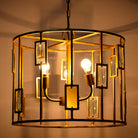 Image showing a lighted version of a unique pendant light with round shiny brass-plated frame and magnifying glass inserts – vintage lighting with three-light design for dining rooms, kitchens, or elegant interiors.