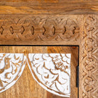 Close up image of a carved wood furniture wardrobe made from mango wood with whitewashed floral doors, wooden wardrobe in Ibiza-inspired style, 100 × 40 × 180 cm.