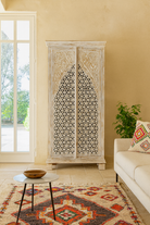 Decorative cabinet with intricate carvings in a living room setting.