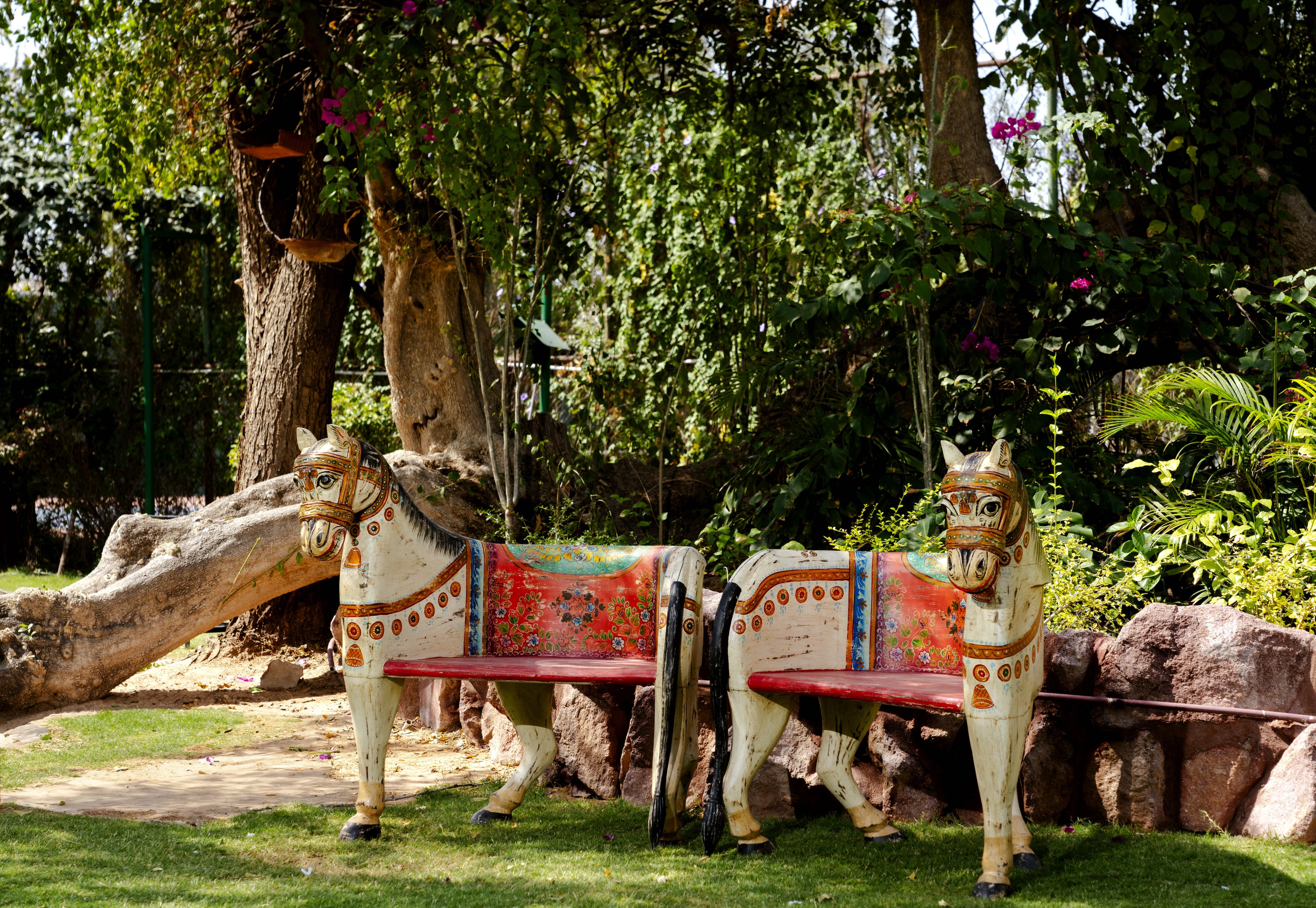 Lifestyle scene with a hand‑painted Horse Chair made from recycled teak wood with carved horse design and vibrant Indian folk art detailing, showcasing artistic and sustainable Indian furniture.