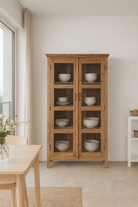 Lifestyle image of a recycled teak wood showcase with four glass-framed doors and internal storage – sustainable teak wood furniture combining timeless elegance and eco-friendly craftsmanship.