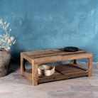 Side view of a coffee table made of reclaimed wood in Wabi Sabi style decorated in a living room scene.