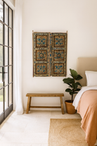 Lifestyle image of a Jodhpur hand-painted wall panel made from an antique Indian teak wood shutter, featuring floral motifs and a weathered finish—an artistic tribute to old Indian door panels.