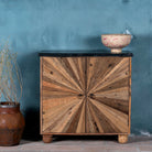 Reclaimed wood sideboard with sunburst carved doors, sliding black marble top, and rustic finish, ideal for rustic interior design.