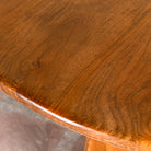 Close up image of a round mango wood dining table with natural grain and sturdy base; solid wooden dining table for dining rooms, 130 cm diameter × 100 cm height.