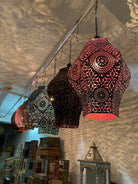Decorative hanging lanterns with intricate patterns in a store setting.