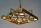 Image with a lighted unique pendant light with square brass-plated iron frame and magnifying blue and white glass inserts – a vintage lighting piece for kitchens, dining rooms, or living areas.