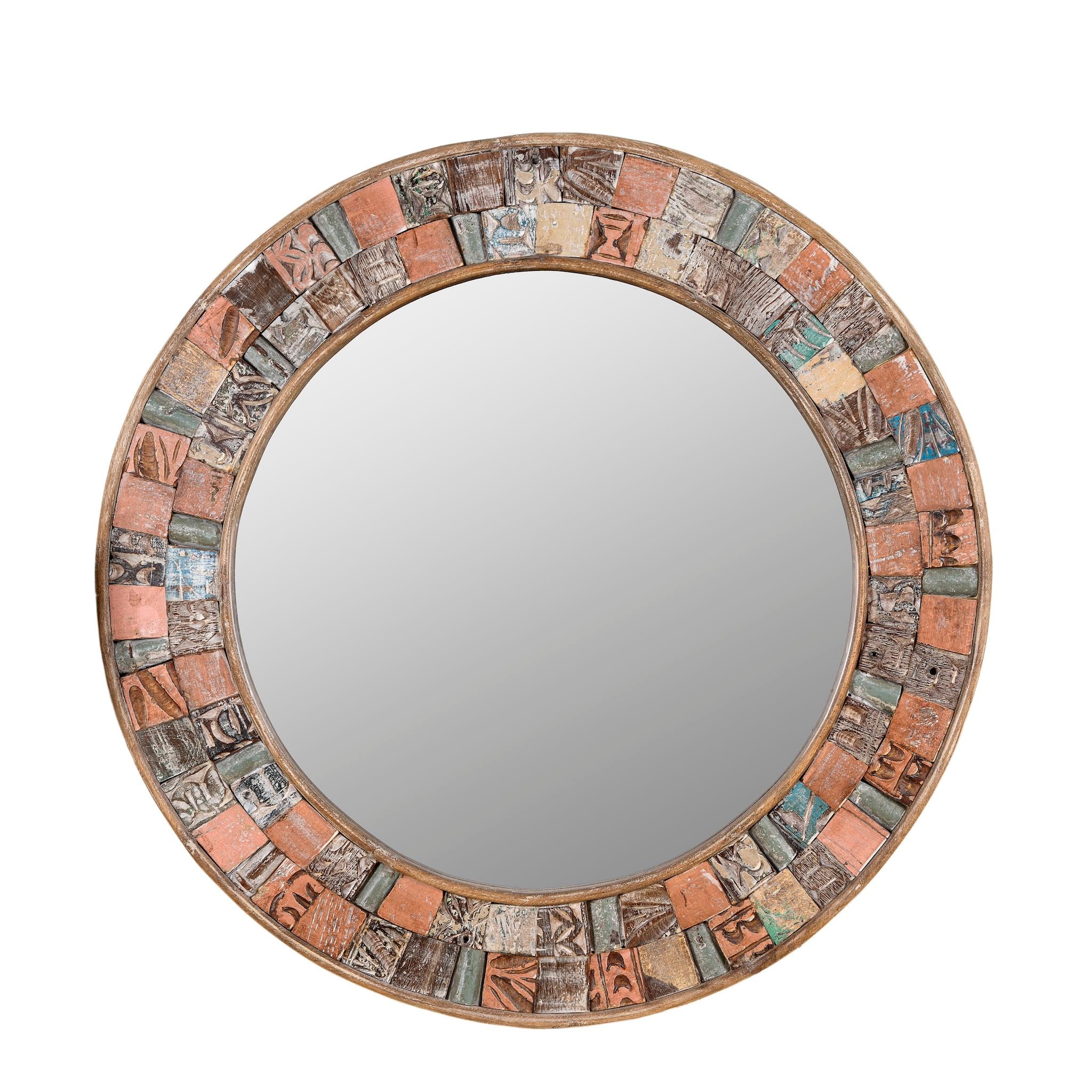 White background image of a round mirror framed with reclaimed wood, featuring a mosaic-style border of intricately carved and coloured wooden tiles, each with unique textures and patterns, creating a rustic and artistic statement piece.
