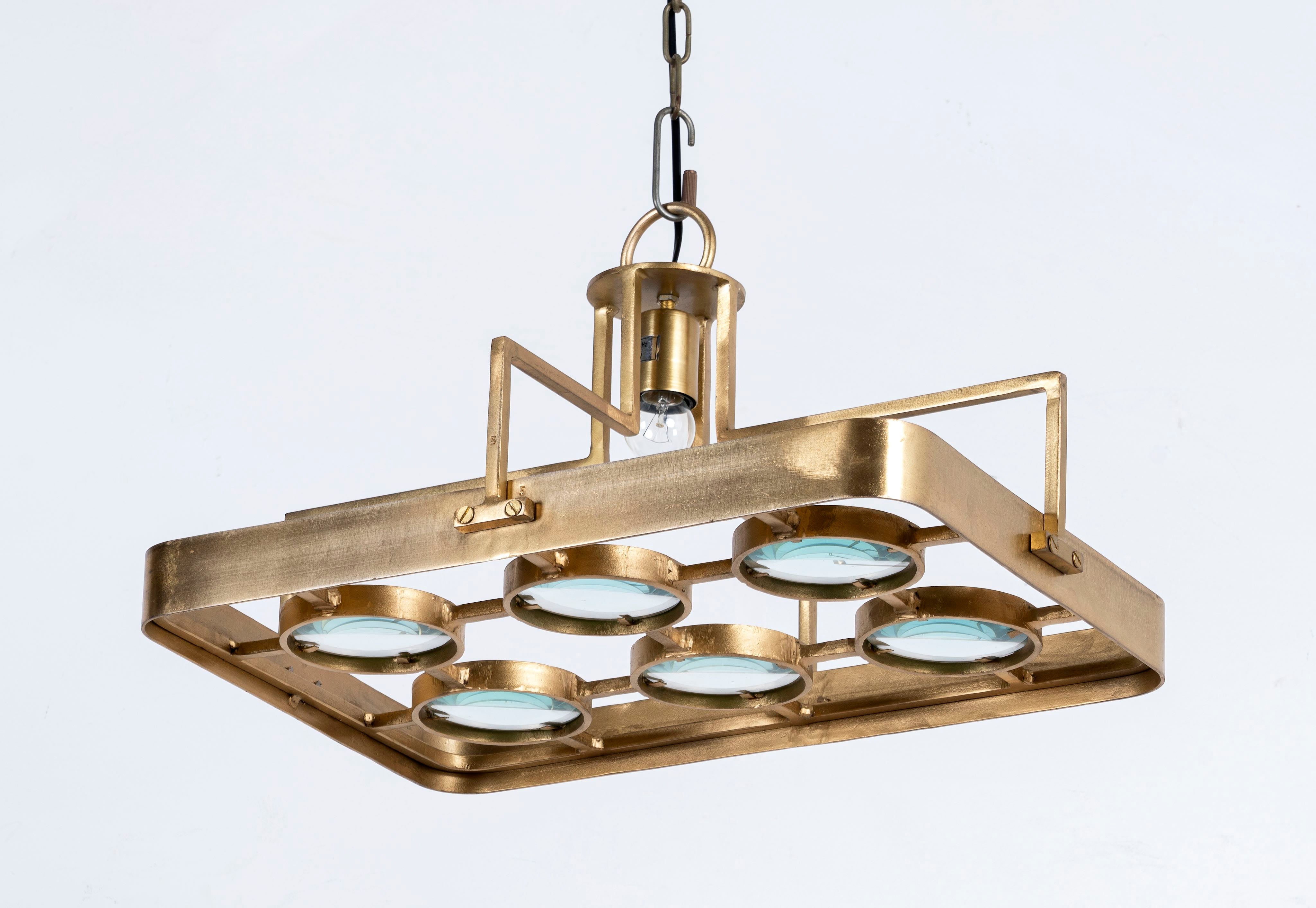 Side angle image of a unique pendant light with brass-plated iron square frame and magnifying blue and white glass inserts – vintage lighting piece ideal for kitchens, living rooms, or entryways.