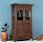 Side angle image of a reclaimed teak wood display cabinet with glass doors – unique Indian furniture with natural wax finish and timeless craftsmanship.