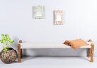 Low mango wood bench with handwoven cotton seat and hand-carved recycled wood frame; 180 × 45 × 20 cm.