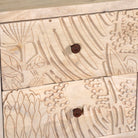 Close up image of a pair of mango wood nightstands with hand-carved sandblasted finish and black iron stand; artisanal bedroom furniture, 51 × 41 × 59 cm.