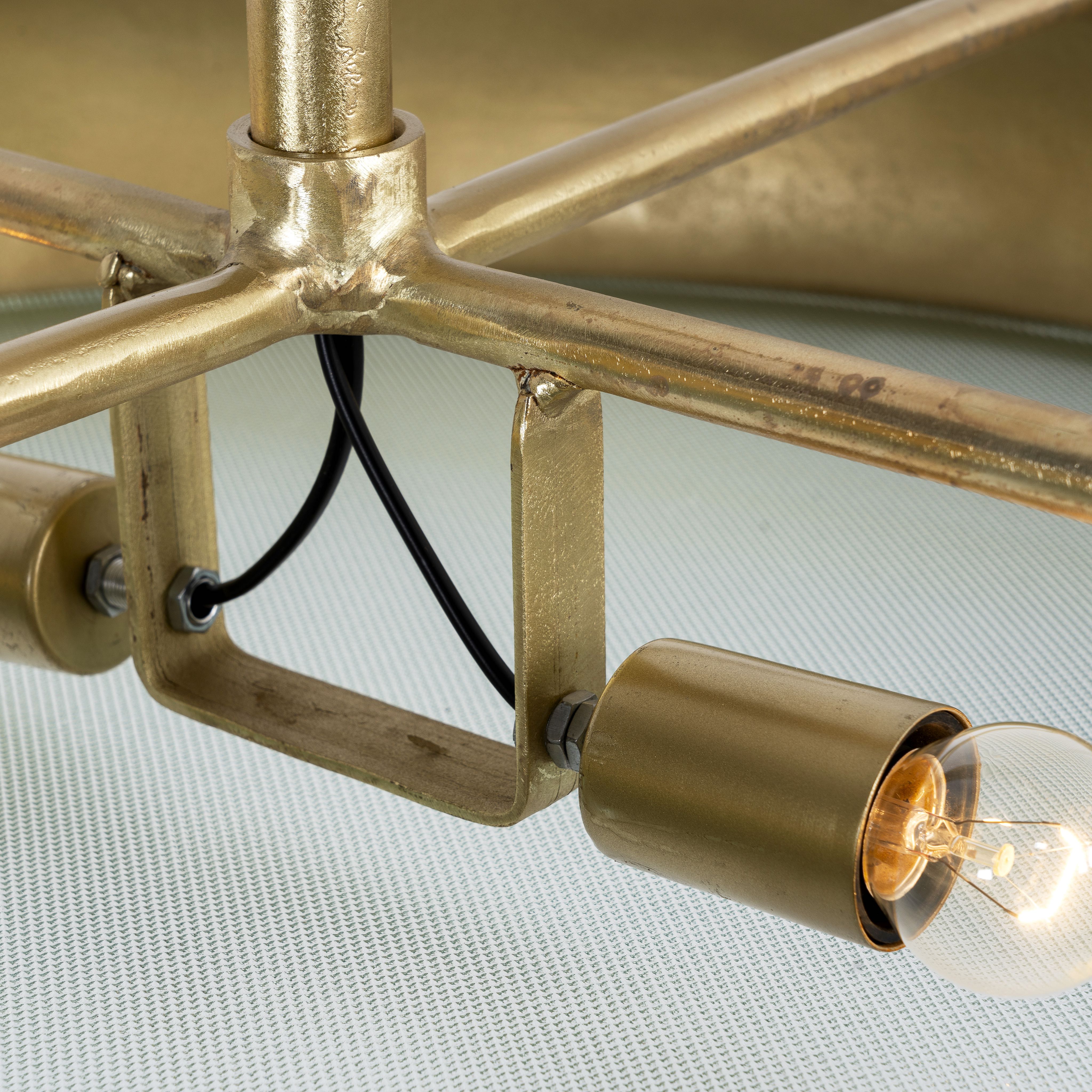 Close up image of extra-large round pendant lamp with clear glass and brass-plated iron frame – retro lighting and artsy lamp ideal for kitchens, dining rooms, or open living spaces.