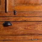 Close up image of a tall reclaimed teak wood display cabinet with two glass doors and a bottom drawer – wooden display cabinet crafted as sustainable furniture with natural elegance.