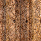 Close up view of a hand carved mango wood cabinet with floral design, 2 doors and one drawer in vintage design.