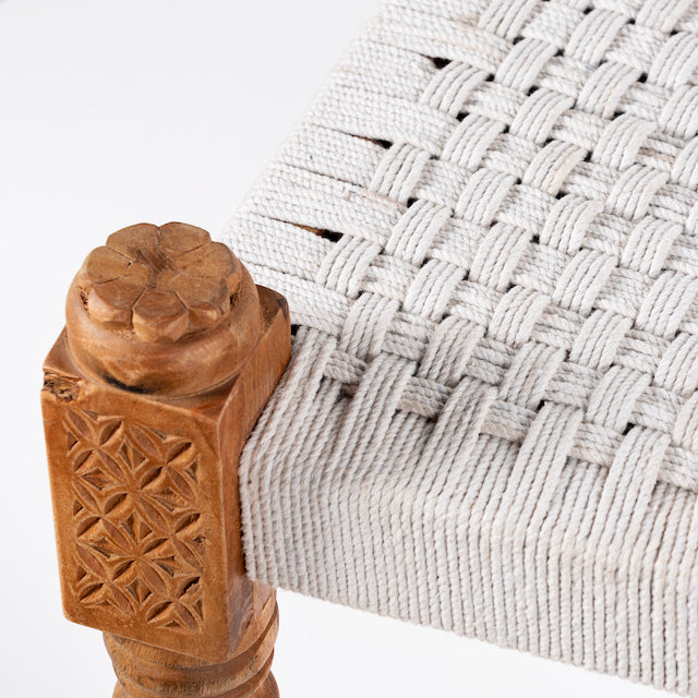 Close up image of a low mango wood bench with handwoven cotton seat and recycled wood frame; Indian daybed-style, 120 × 45 × 20 cm.