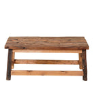White background image of a rustic-style coffee table made from driftwood, showcasing a textured, uneven surface with natural wood tones and grain variations, supported by a sturdy, simple wooden frame, styled in a cozy minimal setting with neutral decor.
