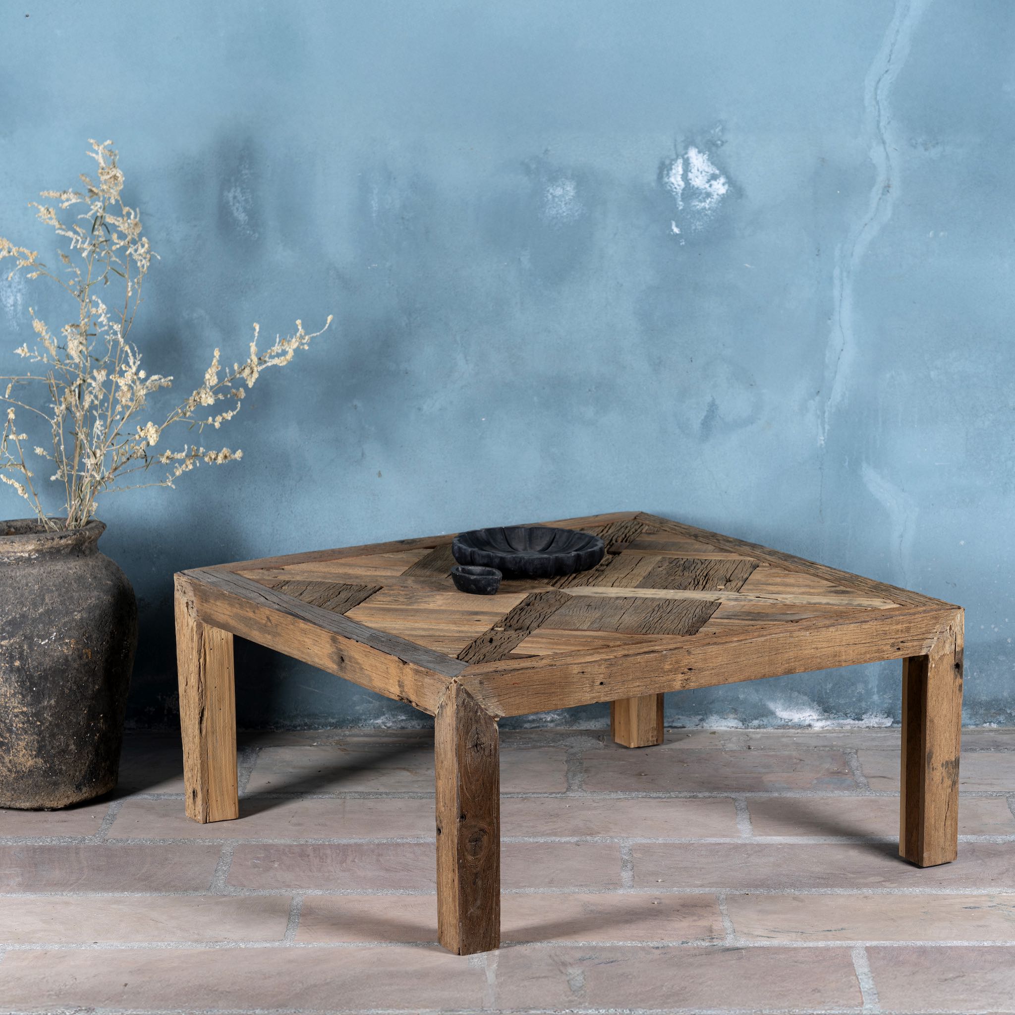 Front image of a square rustic coffee table made from reclaimed wood, featuring a patterned plank tabletop with a natural distressed finish and sturdy block legs for a solid, handcrafted look.
