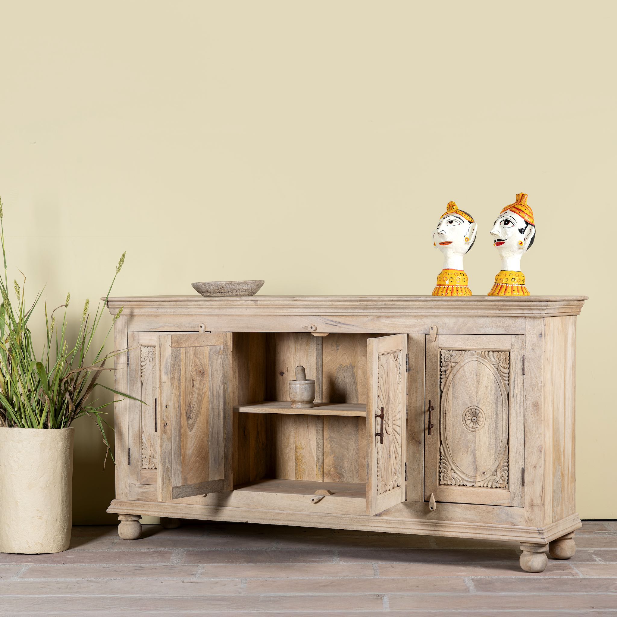 Image with open doors of a hand-carved mango wood sideboard with sandblasted finish – a rustic mango wood furniture piece ideal for Ibiza style interiors.