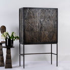 Side angle image of a black wooden cabinet with handcrafted copper inlays and nickel-plated metal base—an artisanal furniture piece with a refined minimalistic style.