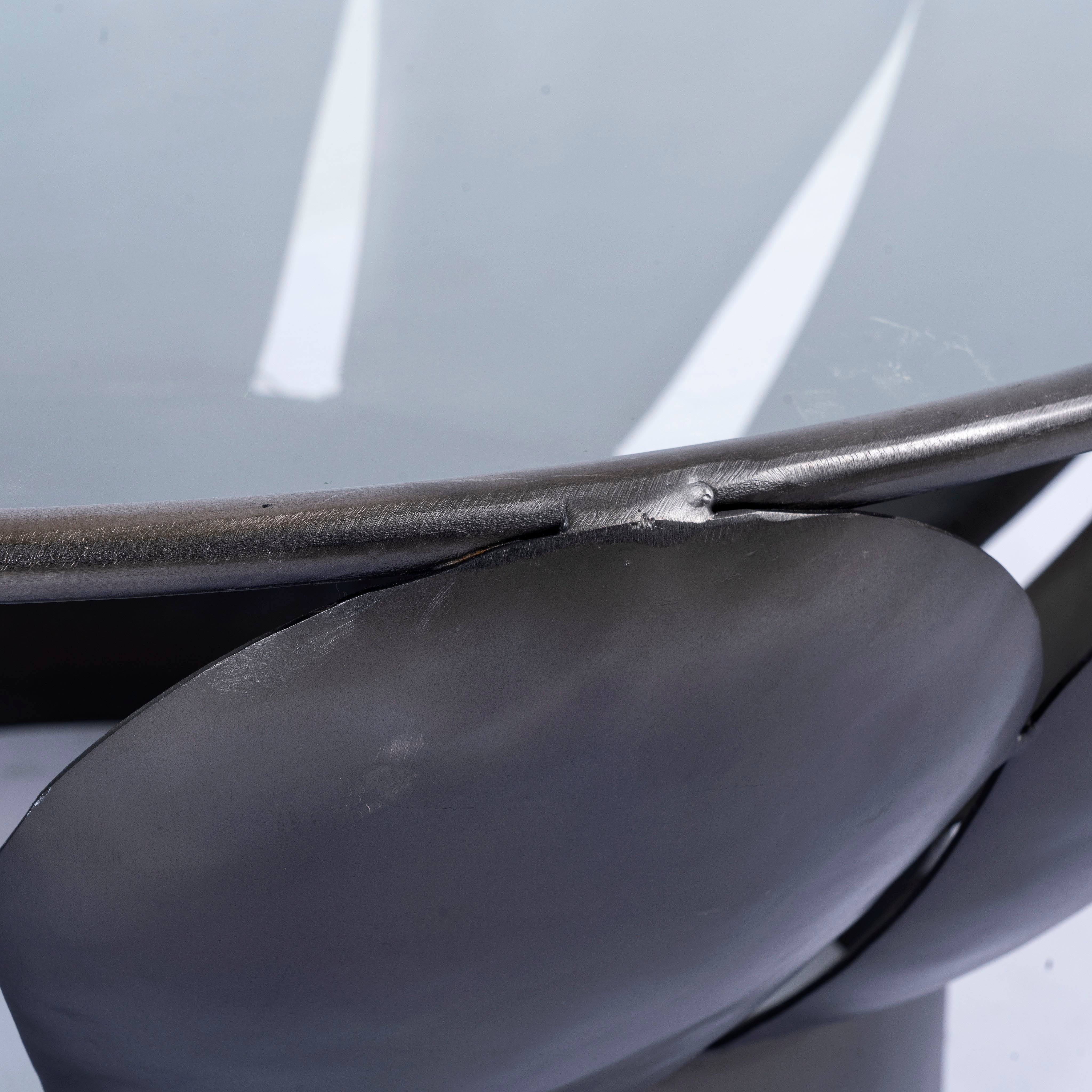Close up image of a round metal base coffee table with petal design and marble top; marble top coffee table with black wrought iron base, 87 cm diameter, 37 cm height.