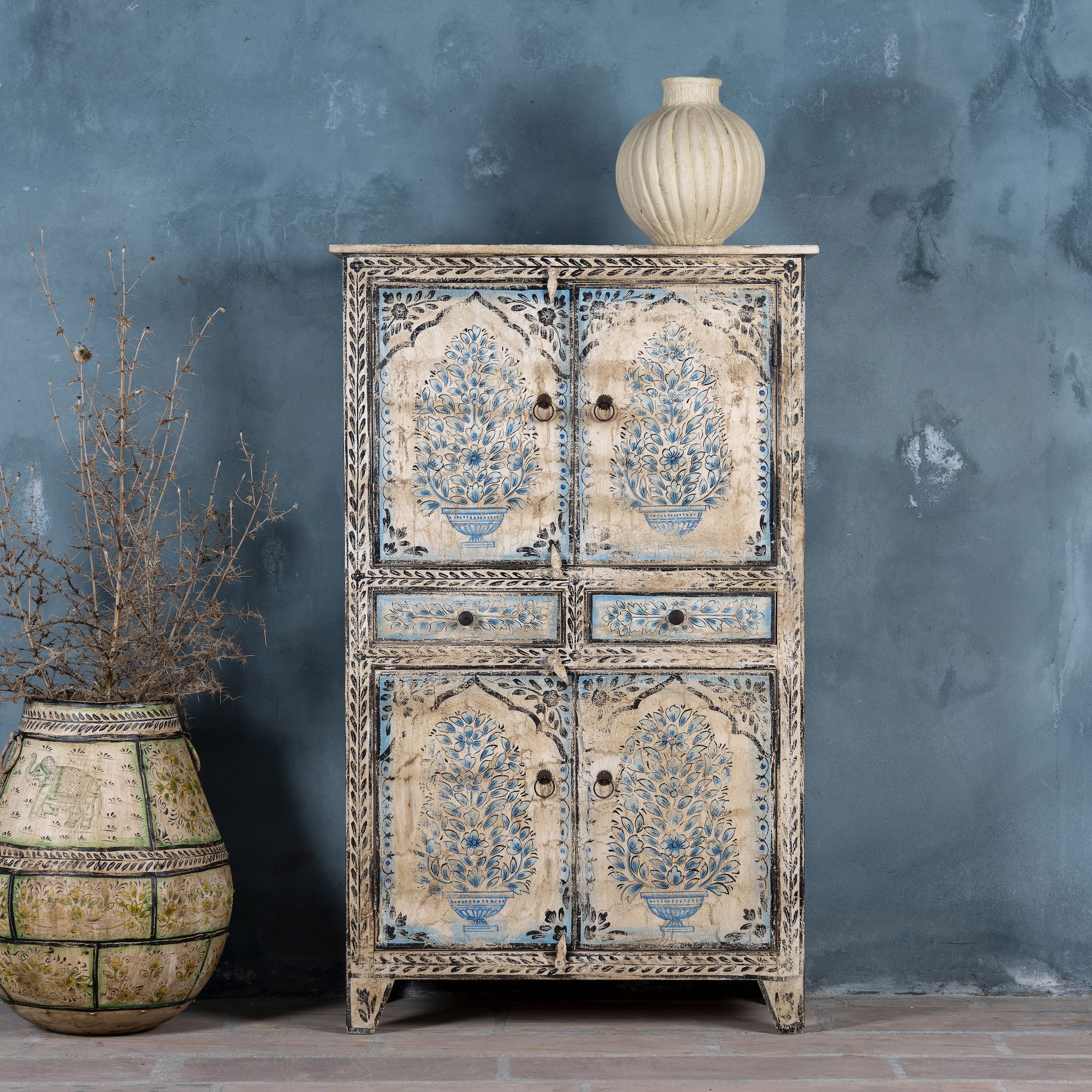 Vintage-style cabinet made from reclaimed wood, featuring intricate hand-painted floral vases in soft blue tones and distressed black detailing for an artisanal heritage look.