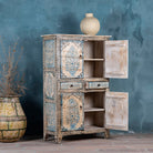 Open door picture of a vintage-style cabinet made from reclaimed wood, featuring intricate hand-painted floral vases in soft blue tones and distressed black detailing for an artisanal heritage look.