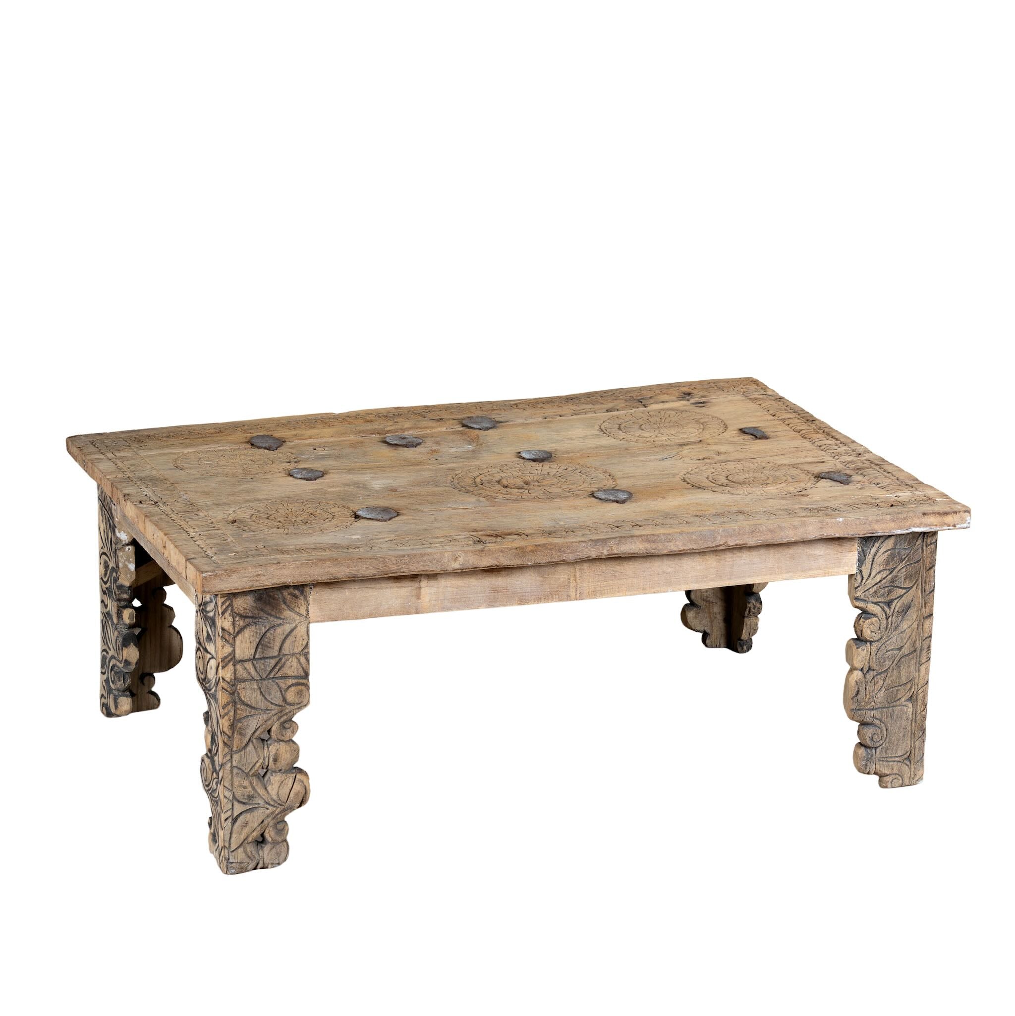 White background image of a sandblasted teak wood coffee table crafted from a hand-carved antique Indian door, featuring intricate traditional motifs and a rustic finish. A reclaimed wood furniture piece that blends cultural heritage with sustainable design.