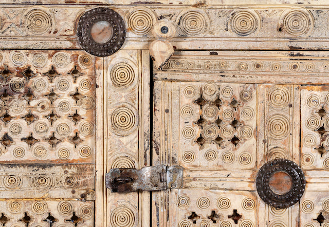 Close up image  of a sandblasted antique Indian teak chest with hand-carved details, original iron fittings, and a naturally aged finish, ideal for bohemian or vintage-inspired interiors.