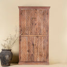 Front view of a hand crafted acacia wood cabinet with 4 doors, brass fitted door knobs and floral carvings.