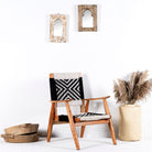 Side angle image of a Acacia wood chair with black-and-white handwoven cotton rope seat and backrest; artisanal wooden armchair, 61 × 47 × 83 cm.