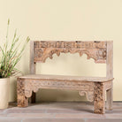 Lifesty;e image of a Shraddha bench made from bleached reclaimed teak wood with intricate hand-carved floral details, showcasing traditional Indian craftsmanship and sustainable furniture design.