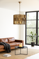 Lifestyle image of a large round brass-plated iron pendant lamp with ornate tile surface – vintage lighting and iron pendant light ideal for dining rooms or living spaces.