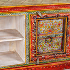 Close up image of a hand-painted reclaimed wood vintage lowboard with floral motifs – a colourful piece of sustainable furniture for artistic and rustic interiors.