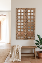 Lifestyle image of a wooden door mirror made from antique teak, part of our Indian home decor collection with original carvings and iron accents.